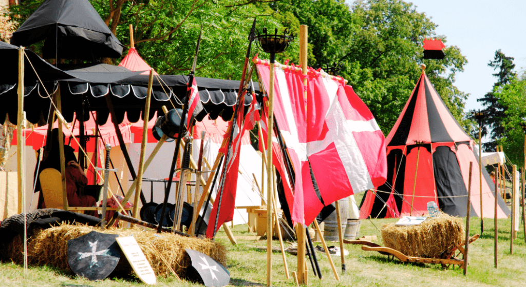 A Renaissance festival setup with heraldic tents and medieval gear.