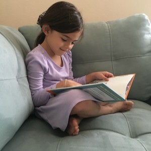 Practicing her newly acquired reading skills.