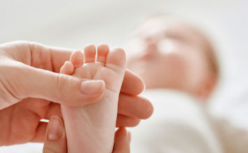 Mom holds baby's toes.