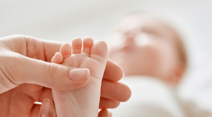 Mom holds baby's toes.