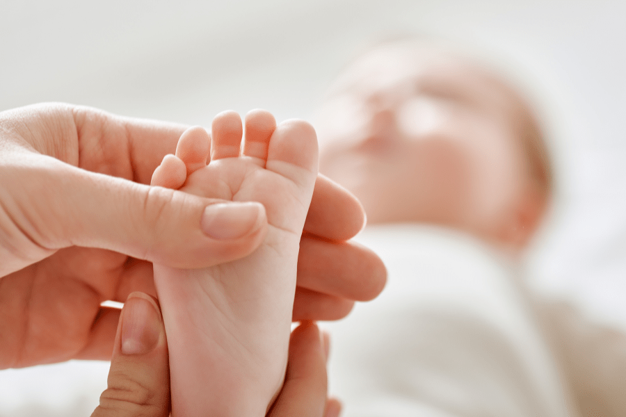 Mom holds baby's toes.