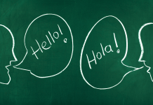 Chalkboard with talking bubbles that say "Hello!" and "Hola!" to raise a bilingual child.