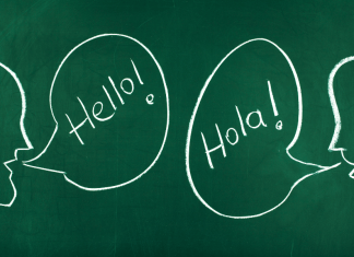 Chalkboard with talking bubbles that say "Hello!" and "Hola!" to raise a bilingual child.