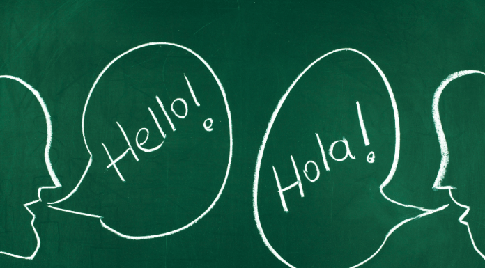 Chalkboard with talking bubbles that say "Hello!" and "Hola!" to raise a bilingual child.