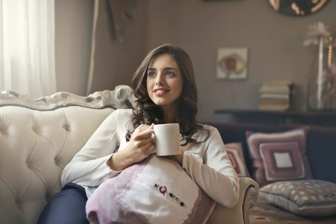 Woman drinking coffee on her couch