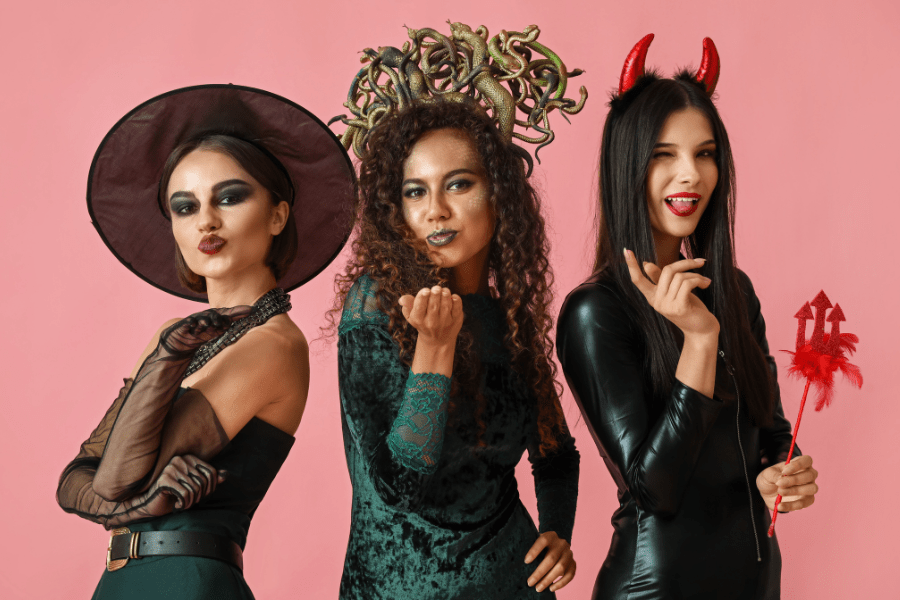 Women dressed up in Halloween costumes as a witch, Medusa, and the devil.