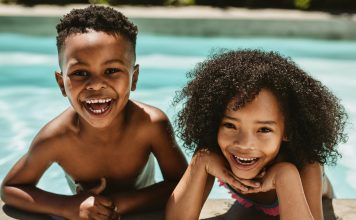 two kids smiling in swimming pool, YMCA Dallas summer camp