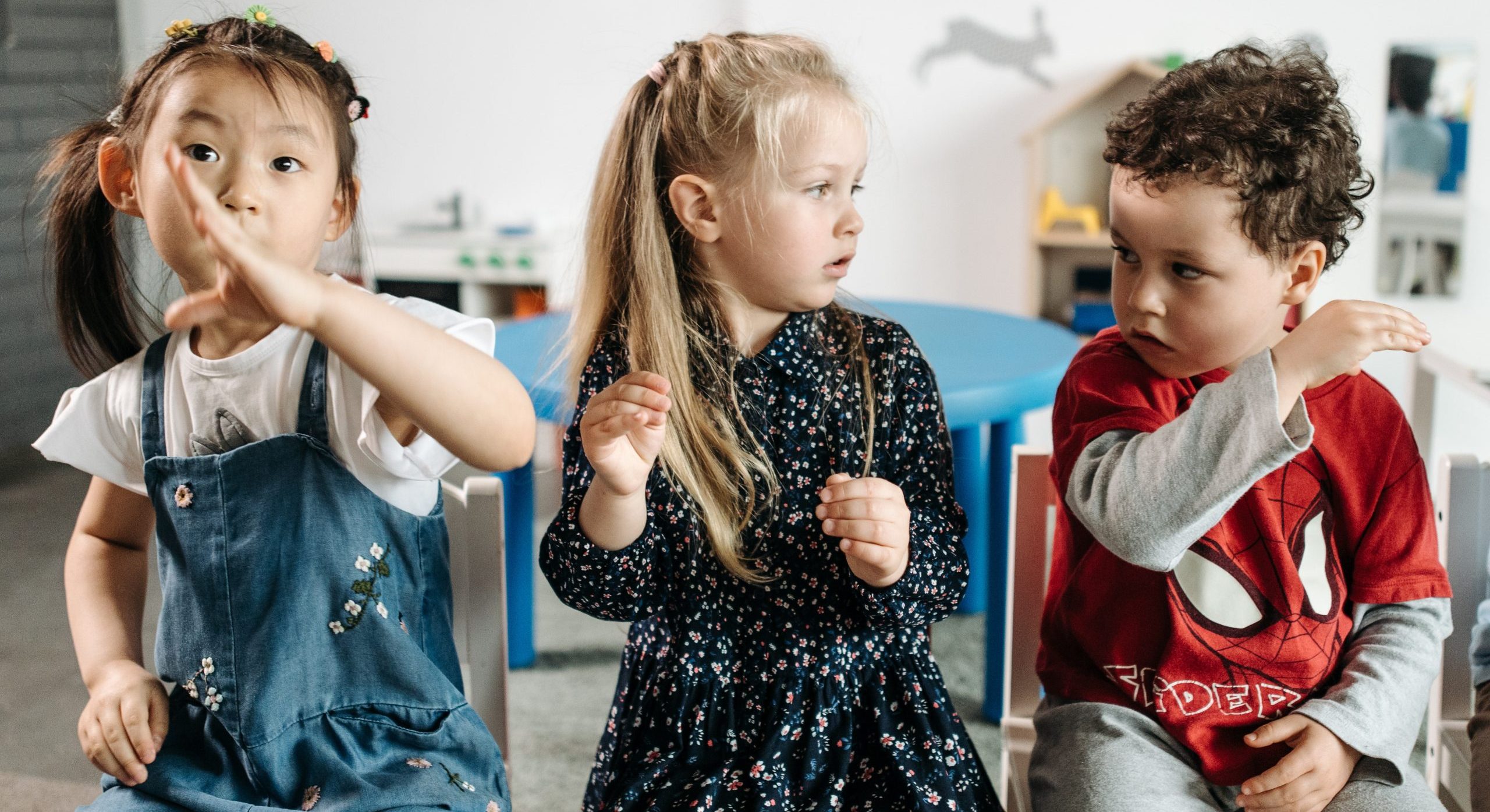 three children in preschool classroom.