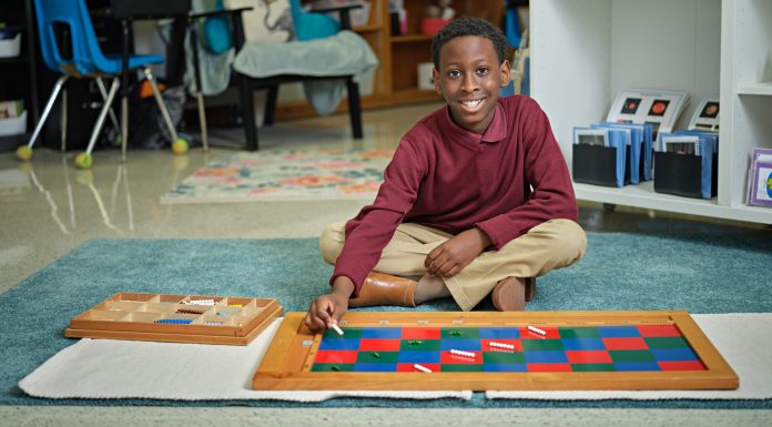 young Black student smiling while working on art project at school