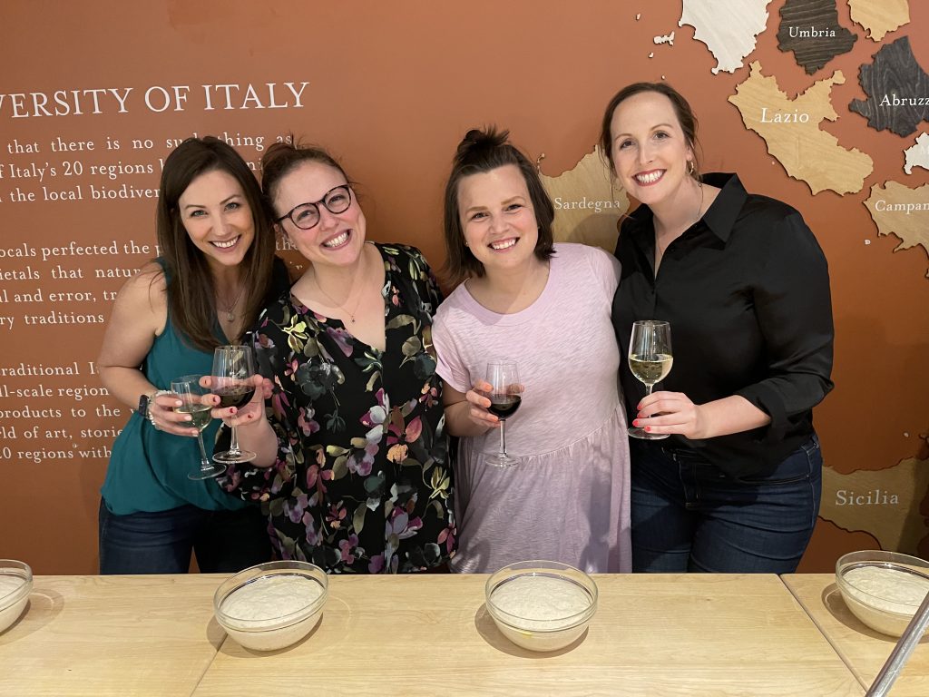 women smiling at pizza making class