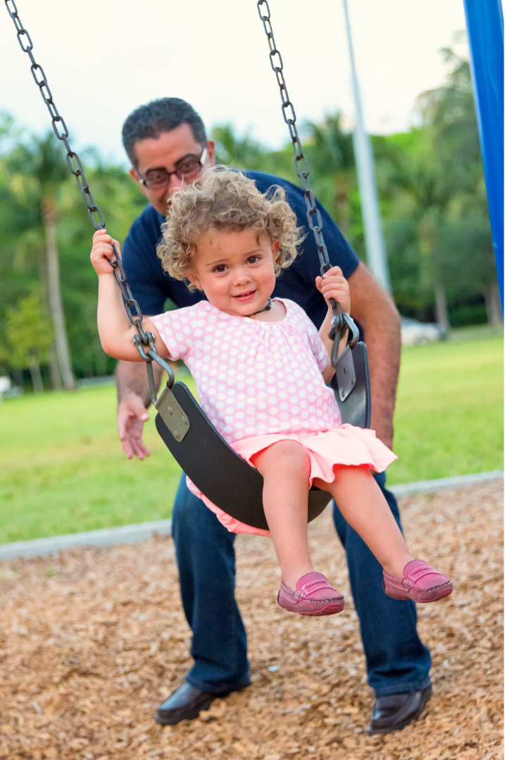 child on swings at Kidd Springs Park in Oak Cliff Dallas