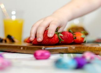 toddler grabbing strawberry