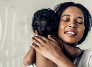 Mom breathes a sigh of relief as she holds and burps baby.