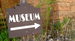 A sign that says museum with an arrow.