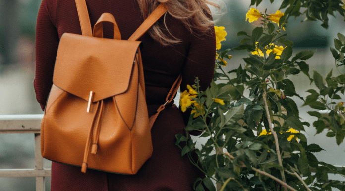 A woman wears a backpack.