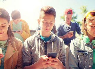 a group of teens all looking at their phones