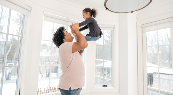 A mom swings her daughter in the air.