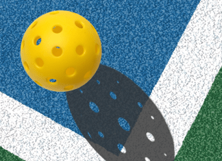 A yellow pickleball on a court.