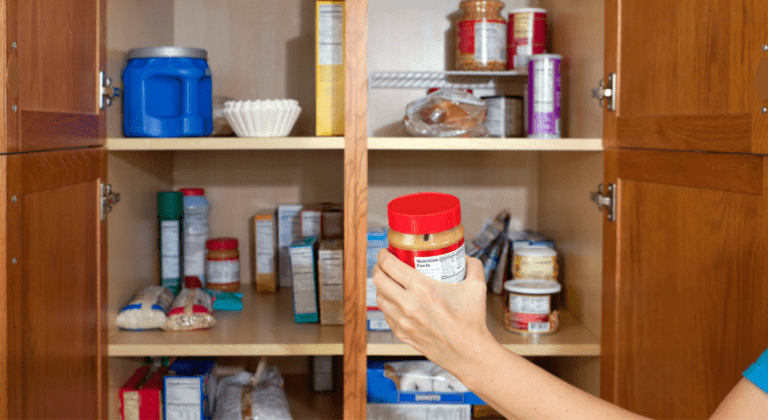 A hand reaches into a pantry.