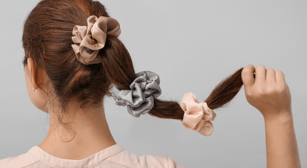 A woman wears three scrunchies in her hair.