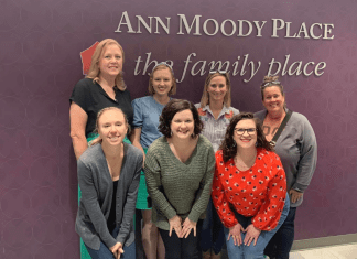 Seven women from the Dallas Moms team visting the Ann Moody room at The Family Place