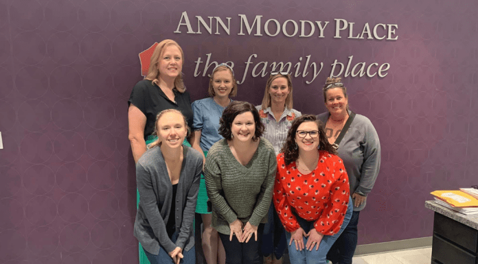 Seven women from the Dallas Moms team visting the Ann Moody room at The Family Place