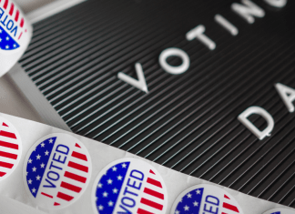 Voting day letter board with I voted stickers on table.