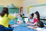 teacher with elementary kids at round table