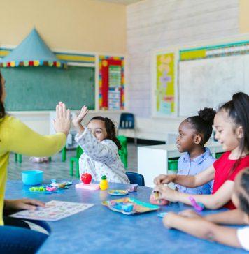 teacher with elementary kids at round table