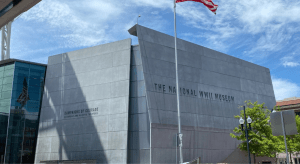 Facade of National WW2 Museum in Louisiana with American Flag in front of it.