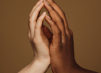 Hands of an interracial couple touch lovingly