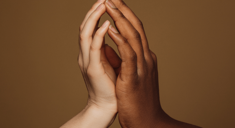 Hands of an interracial couple touch lovingly