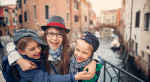 Mom and kids hug while on a trip to Venice, Italy.