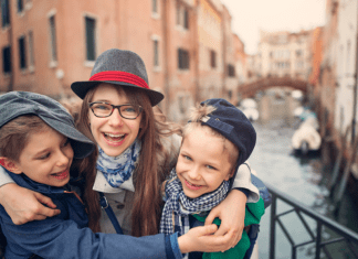 Mom and kids hug while on a trip to Venice, Italy.