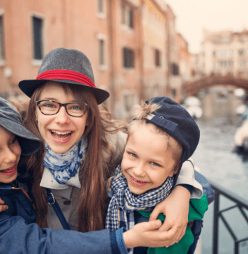 Mom and kids hug while on a trip to Venice, Italy.