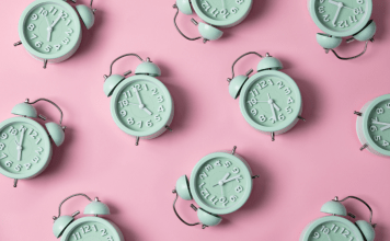 Green alarm clocks set to 5:00 and after on a pink background.