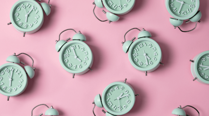 Green alarm clocks set to 5:00 and after on a pink background.