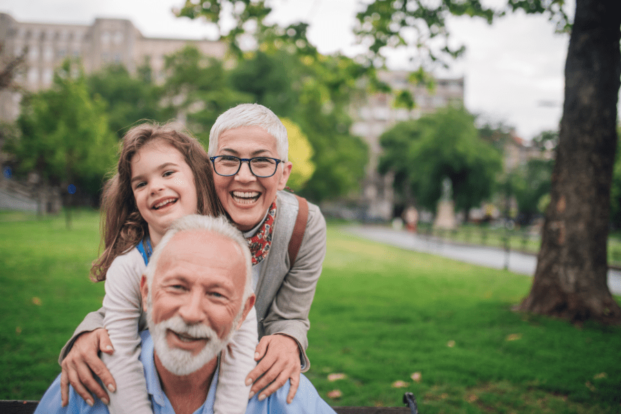 Grandparents with granddaughter in the park.