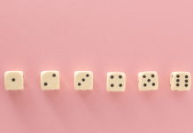 6 dice in a row on a pink background showing dots from 1-6