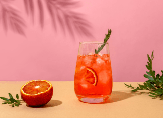 Negroni cocktail and a blood orange on a pink background