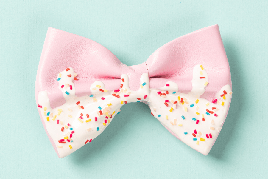 Pink bow with a sprinkles and frosting design