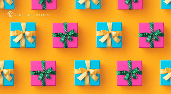 Presents wrapped in pink and blue with gold and green ribbons sit on a bright orange surface.